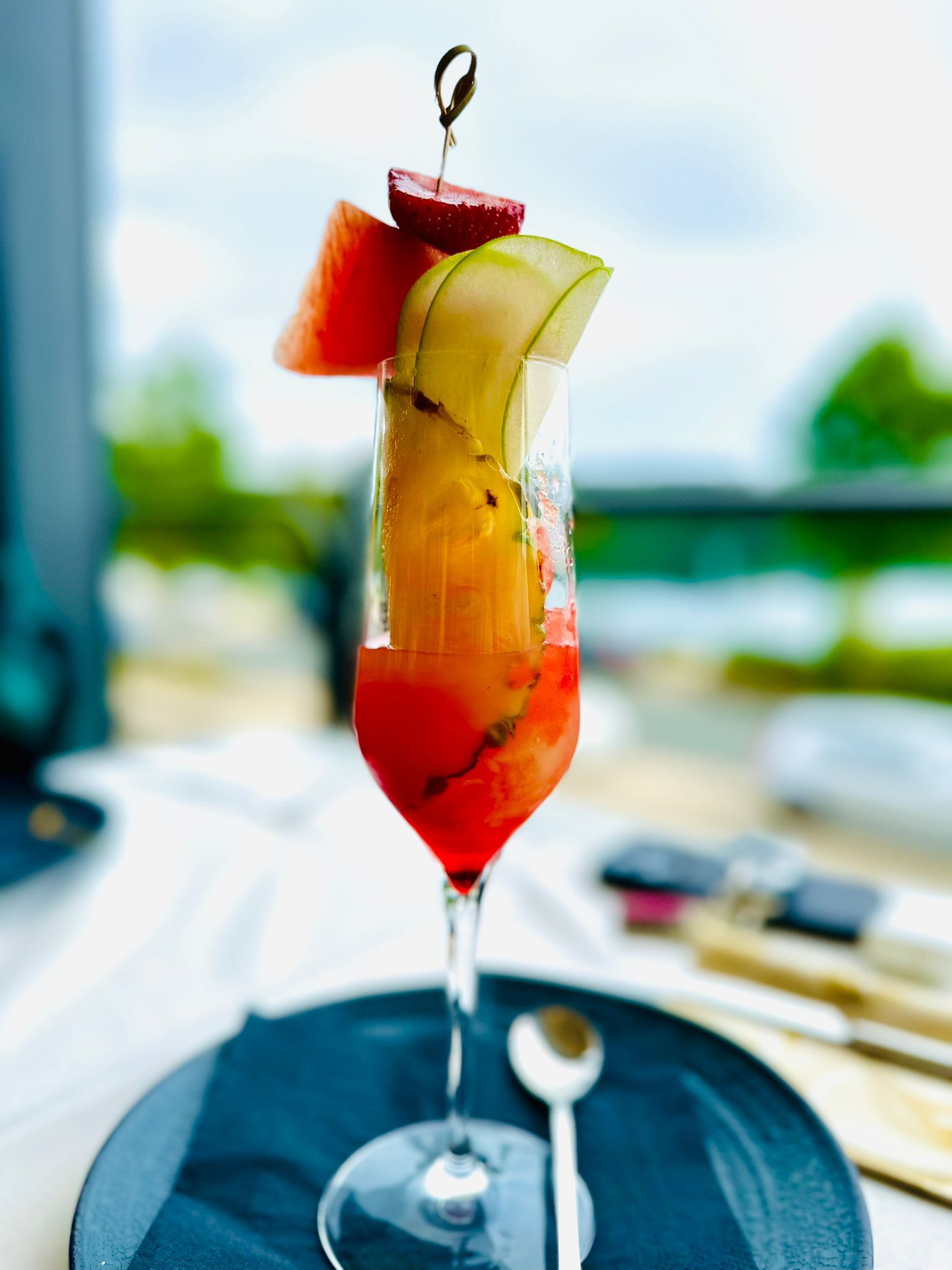 c95cc38a-d4eb-4c9f-8250-3a913271400b Cocktail im Vodergrund, Außenbereich im Hintergrund